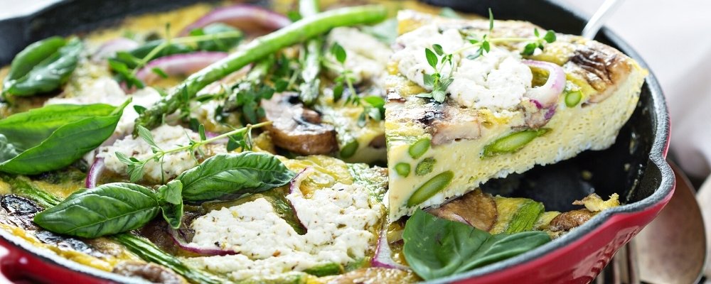 asparagus and goat cheese frittata sitting in a cast iron skillet